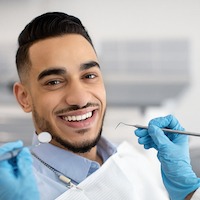 Man Smiling While Getting Dental Work