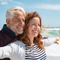 older white man and woman smiling outdoors 